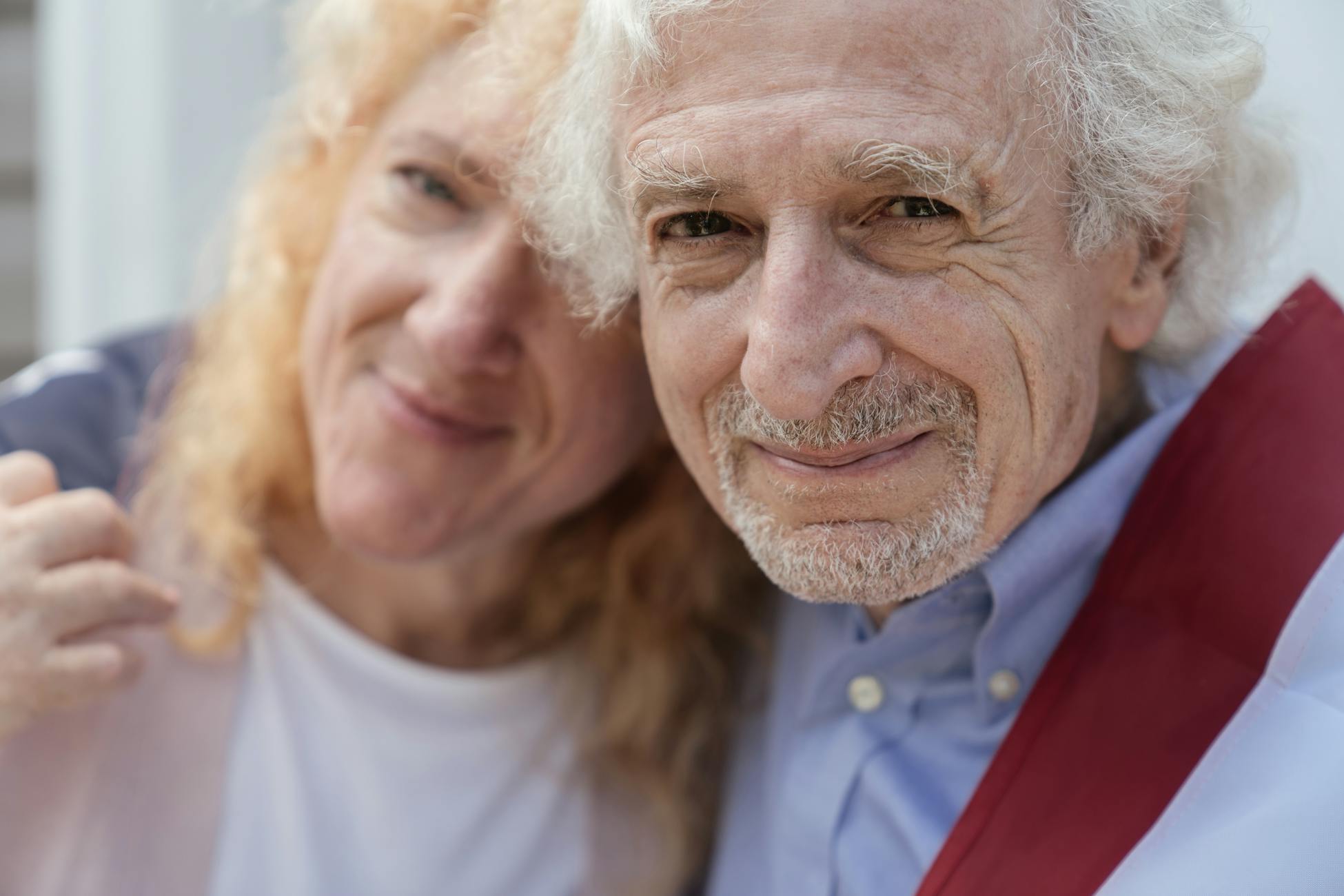 Close-up of a happy elderly couple smiling together outdoors, exuding love and togetherness.