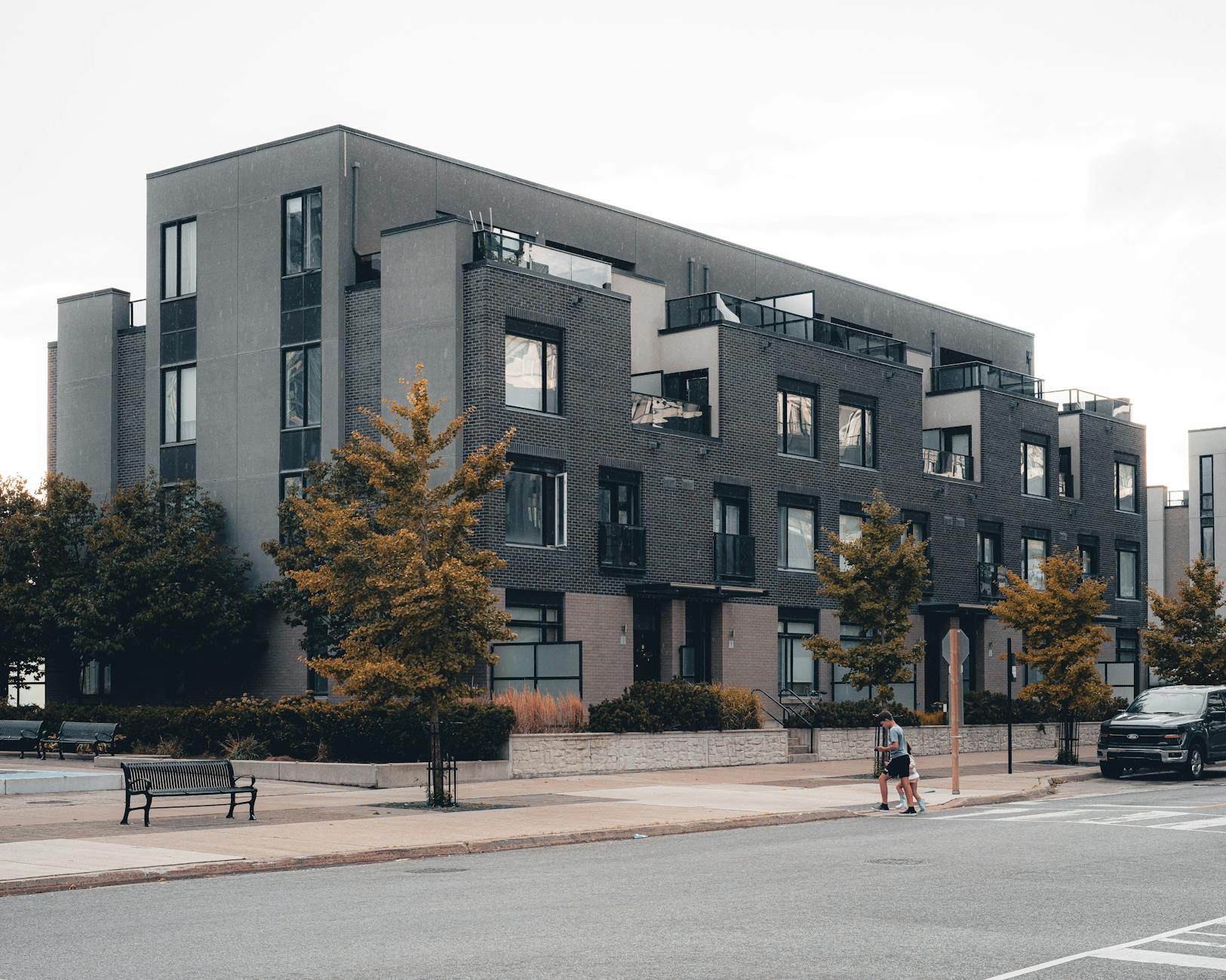 Contemporary urban apartment building with tree-lined street in Mississauga, Ontario.