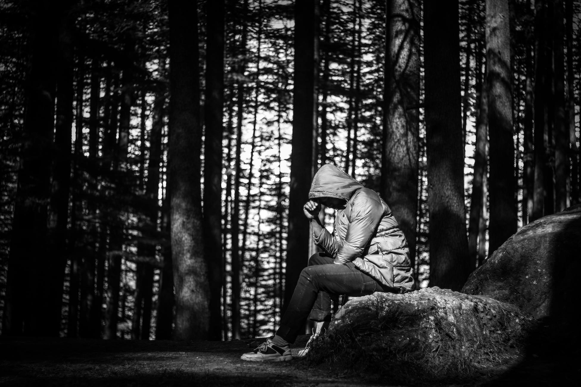 A person in deep thought, seated in a serene Manali forest, India.